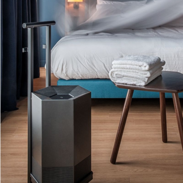 purificateur d'air shield by JVD dans une chambre d'hôtel sur un chariot de transport